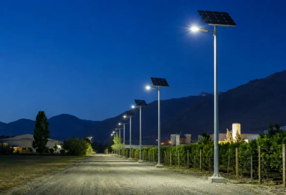 Camino industrial iluminado de noche con luminarias solares autónomas sobre postes